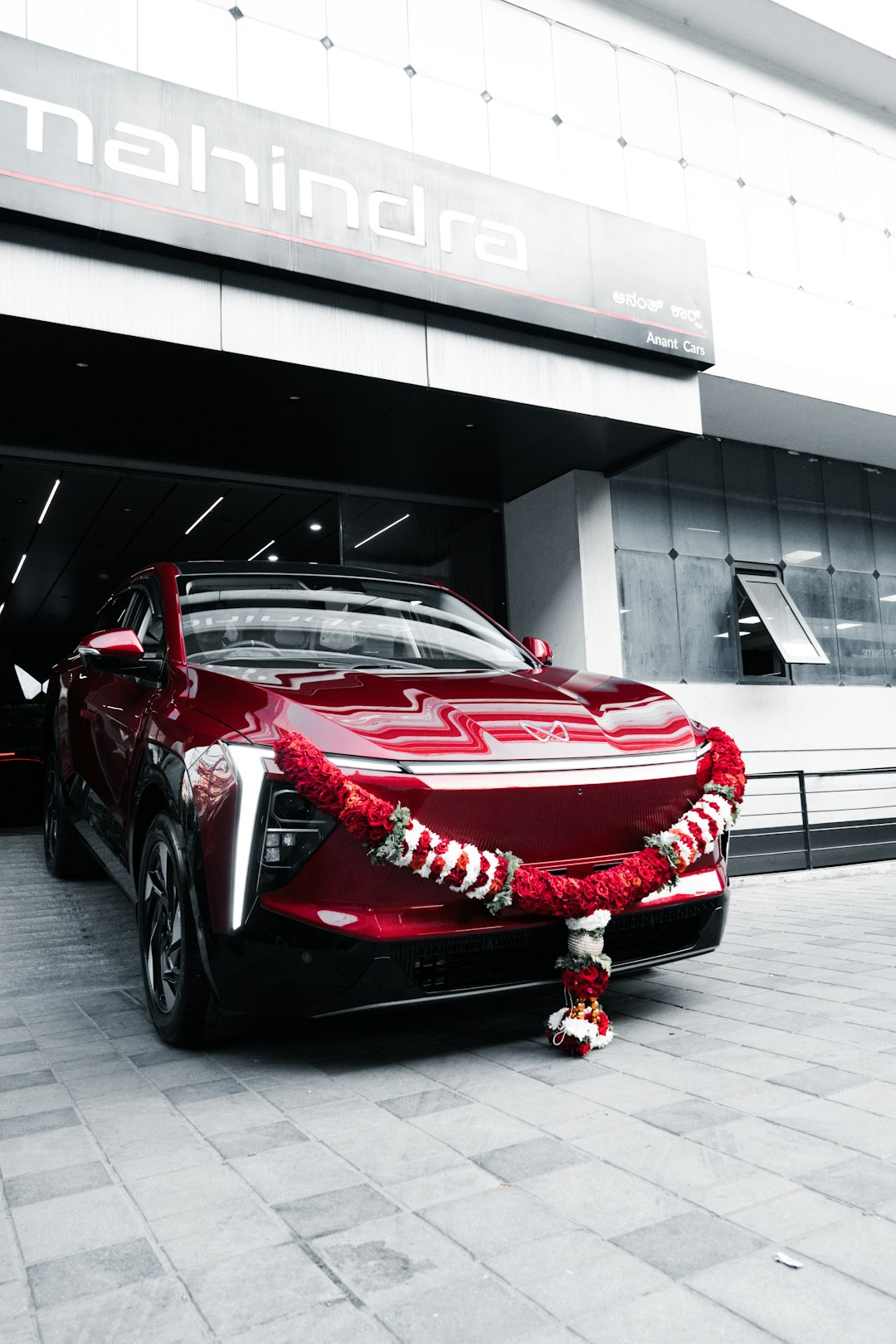 A new red car decorated with a garland on delivery day